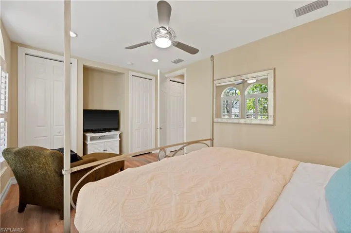Bedroom featuring two closets, wood finished floors, ceiling fan, and recessed lighting