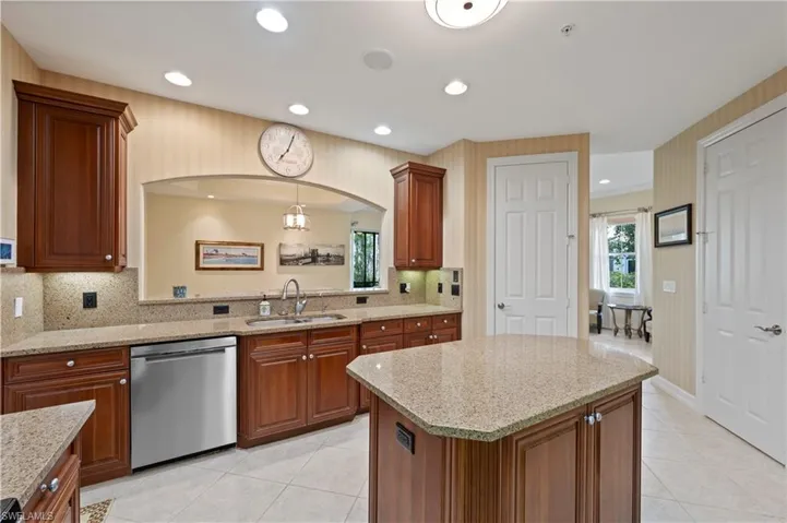 Kitchen with stainless steel dishwasher, light stone counters, light tile patterned flooring, and recessed lighting