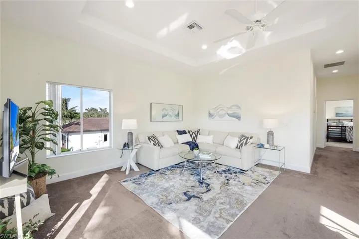 Second-floor living room with plenty of natural light and ceiling fan.