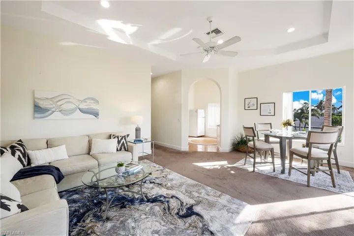 Spacious second-floor living room with ceiling fan and a raised ceiling.