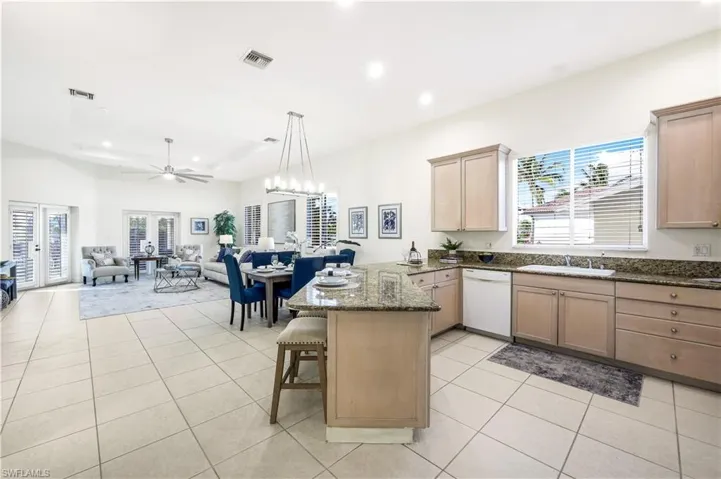 Kitchen with peninsula breakfast bar and large window.