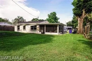 Rear view of property featuring a yard and a sunroom