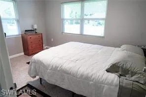 Carpeted bedroom with multiple windows