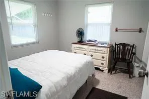 Carpeted bedroom with multiple windows
