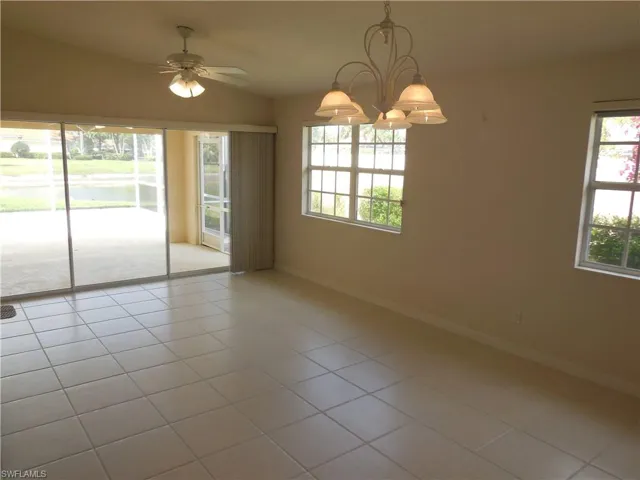 Unfurnished room featuring light tile patterned floors, a ceiling fan, suspended lighting, and lofted ceiling