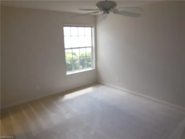 Unfurnished room with light colored carpet and a ceiling fan