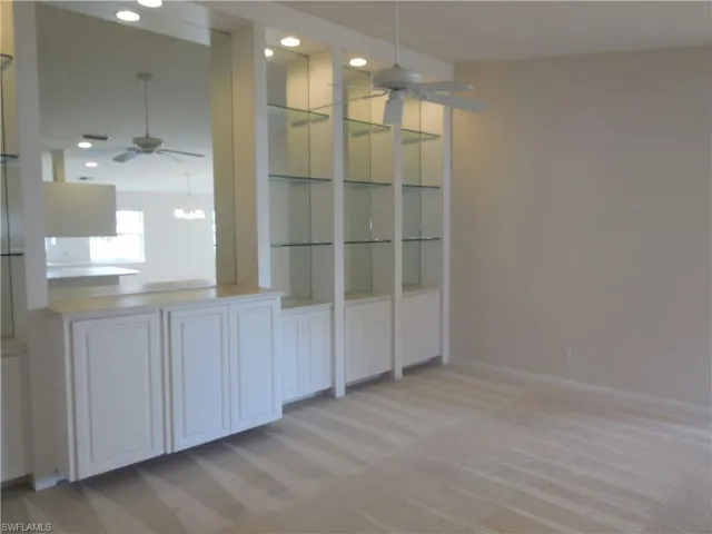 Unfurnished dining area with a ceiling fan, light colored carpet, and recessed lighting