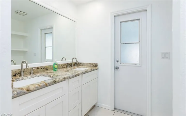 Full bathroom with tile patterned flooring, double vanity, and a sink