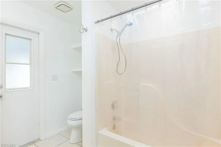 Full bathroom with tile patterned floors, toilet, and tub / shower combination