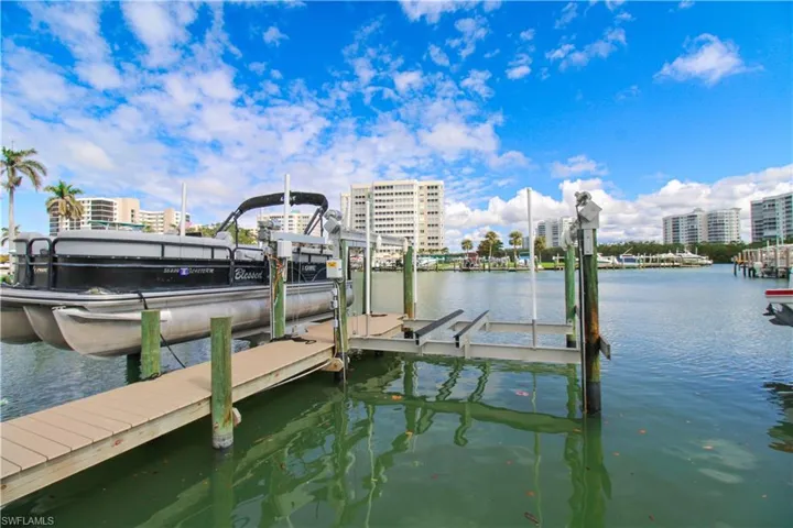 Dock area with a view of city, a water view, and boat lift