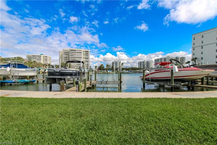 View of dock with a lawn, a water view, and boat lift