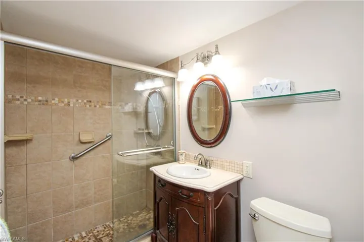 Bathroom with a shower stall, toilet, and vanity