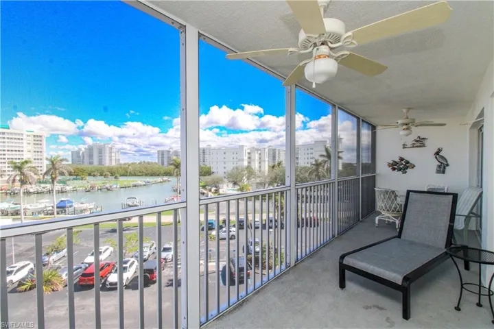 Balcony featuring a ceiling fan, a view of city, and a water view
