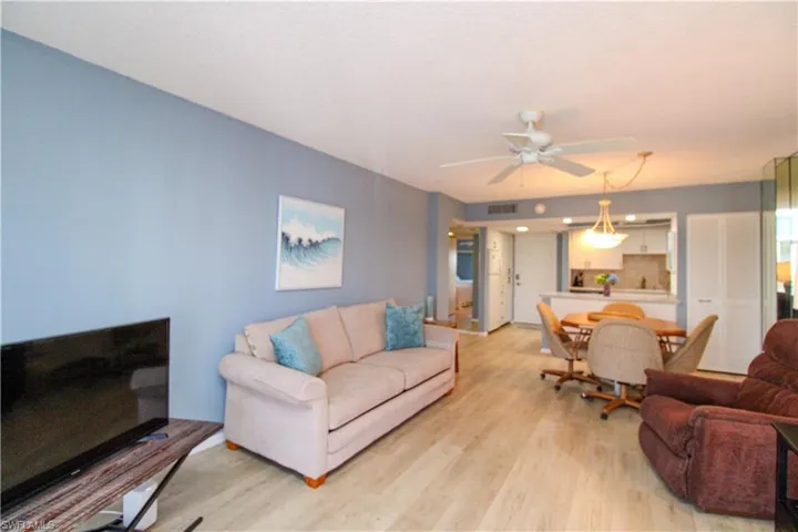 Living room with a ceiling fan, light wood-type flooring, and visible vents