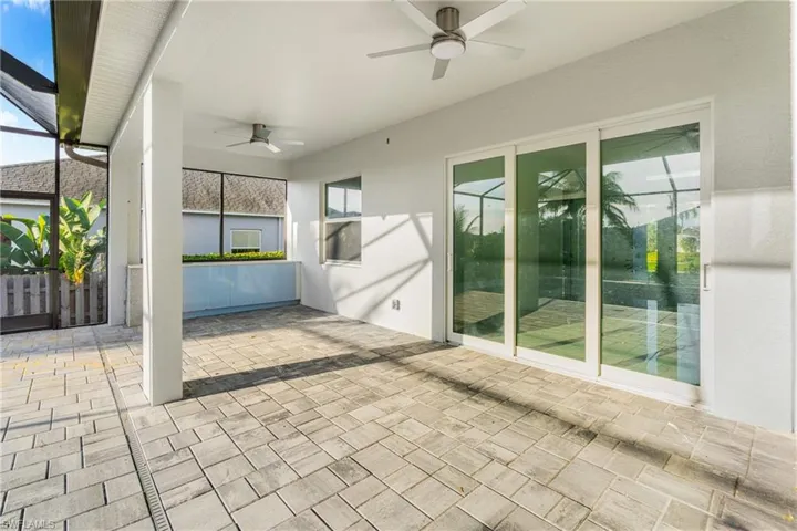 View of patio featuring a ceiling fan and a lanai