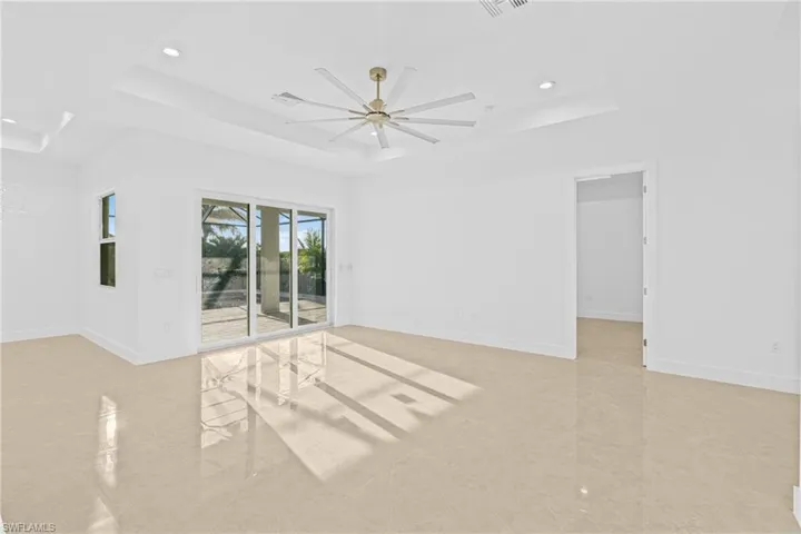 Unfurnished room featuring a tray ceiling, a ceiling fan, and recessed lighting