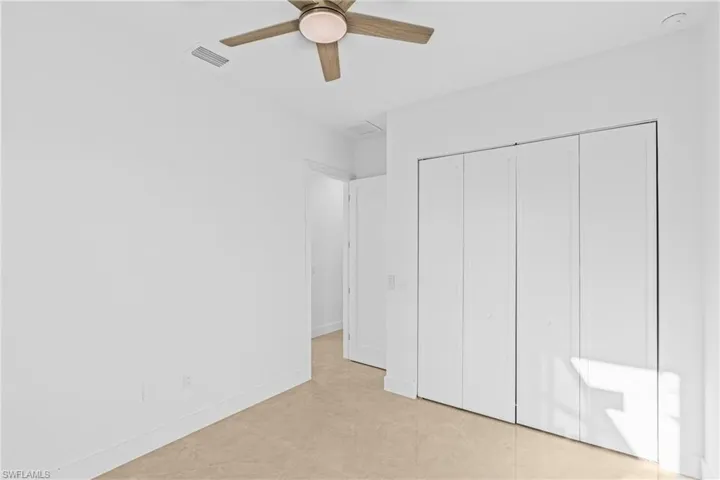 Unfurnished bedroom with a closet, ceiling fan, and light tile patterned floors
