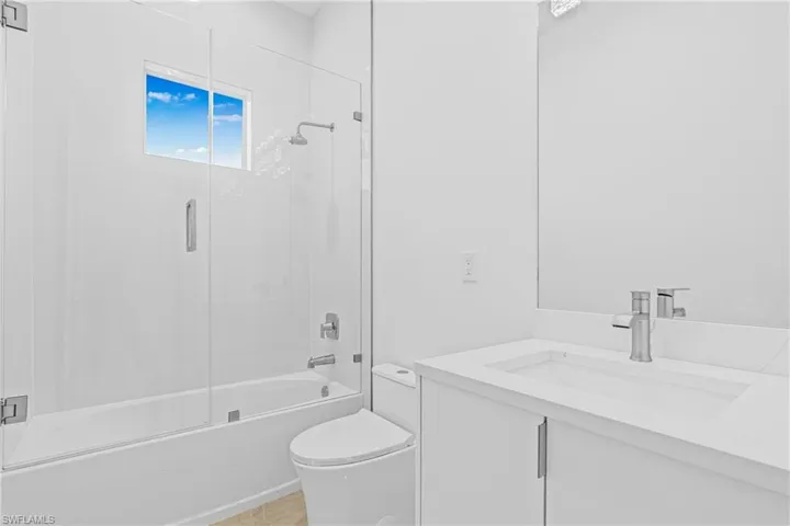 Bathroom featuring enclosed tub / shower combo and vanity
