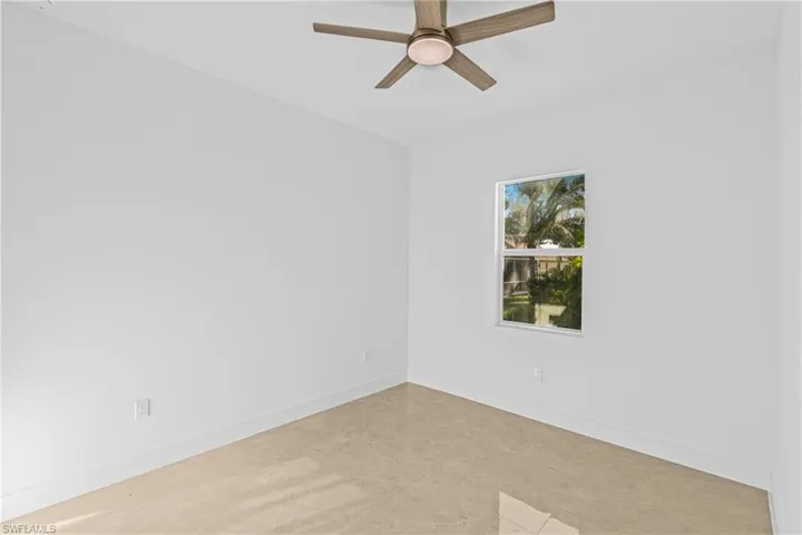Spare room featuring baseboards and ceiling fan