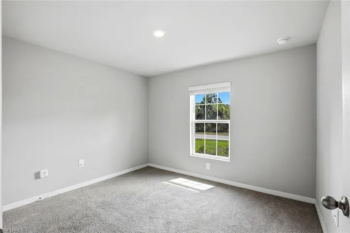 Empty room with baseboards and light carpet