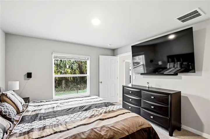 Bedroom with light carpet and baseboards