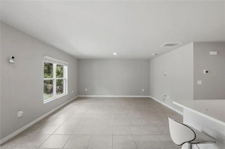 Empty room with light tile patterned flooring and recessed lighting
