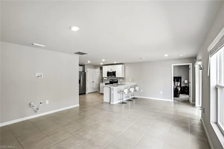 Living room with recessed lighting and light tile patterned flooring