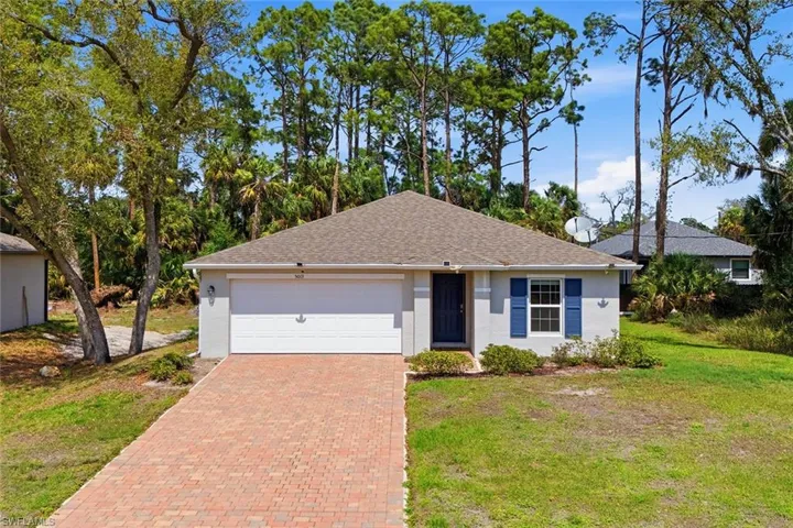 Ranch-style house with decorative driveway, a front yard, stucco siding, and a garage