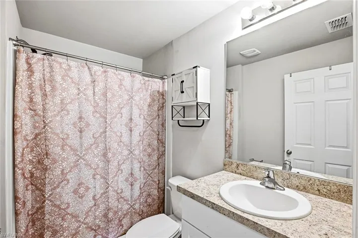 Full bathroom with vanity and a shower with curtain