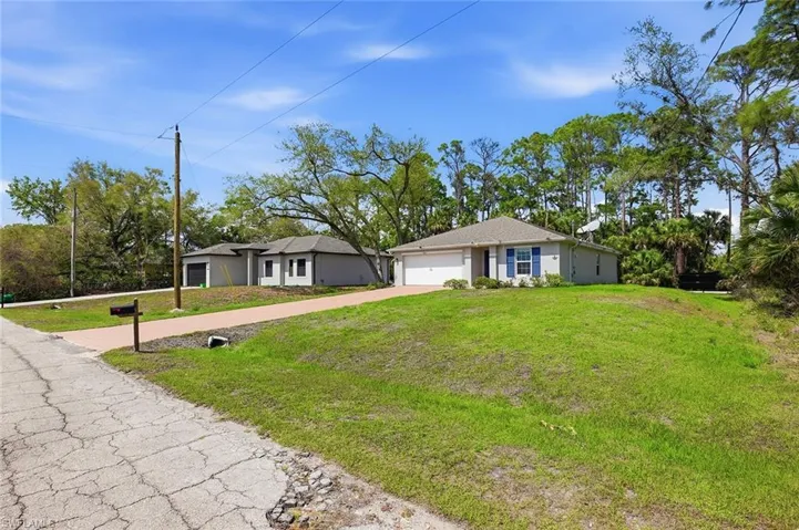 Ranch-style house featuring a front yard, an attached garage, and concrete driveway