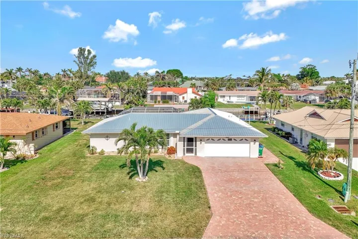 View of front of property with a garage and a front lawn