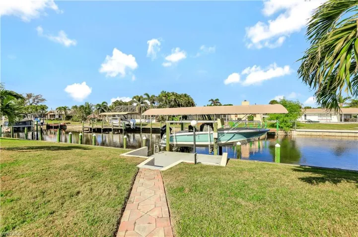 Dock area with a yard and a water view