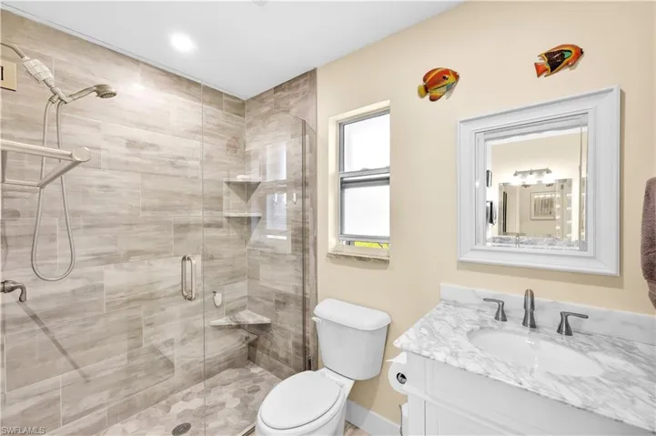 Bathroom featuring vanity, toilet, and a shower with shower door