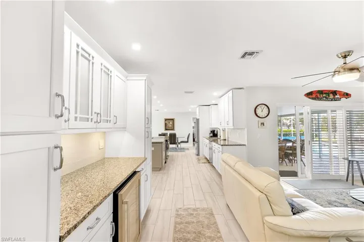 Kitchen featuring white cabinetry, tasteful backsplash, and light stone countertops