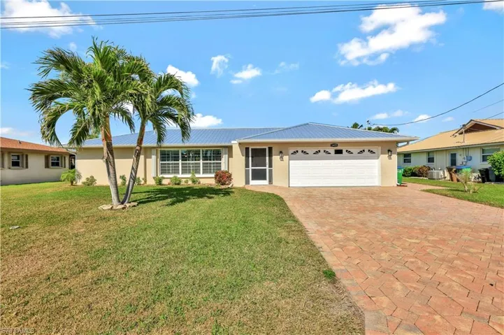 Single story home with cooling unit, a garage, and a front yard