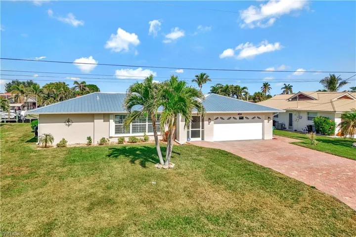 Ranch-style house featuring a garage and a front lawn