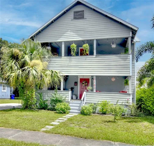 View of front of home with a balcony and a front yard