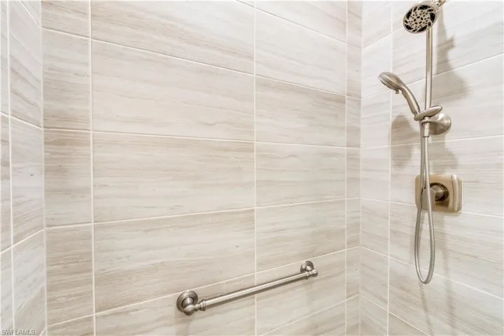 Junior Suite Shower with grab bar and upgraded handheld shower fixture.