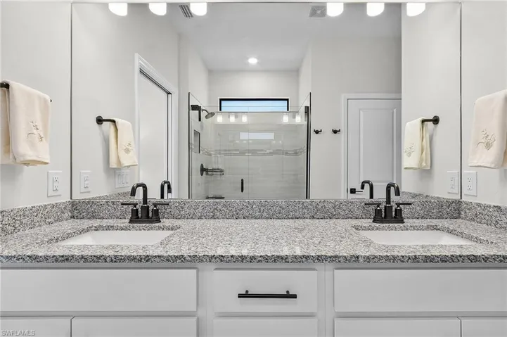 Dual vanity with gray speckled countertop and undermount sinks