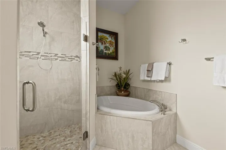 Bathroom featuring a garden tub, a shower stall, and tile patterned floors