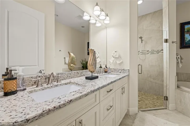 Bathroom with double vanity, a stall shower, a bath, and tile patterned flooring