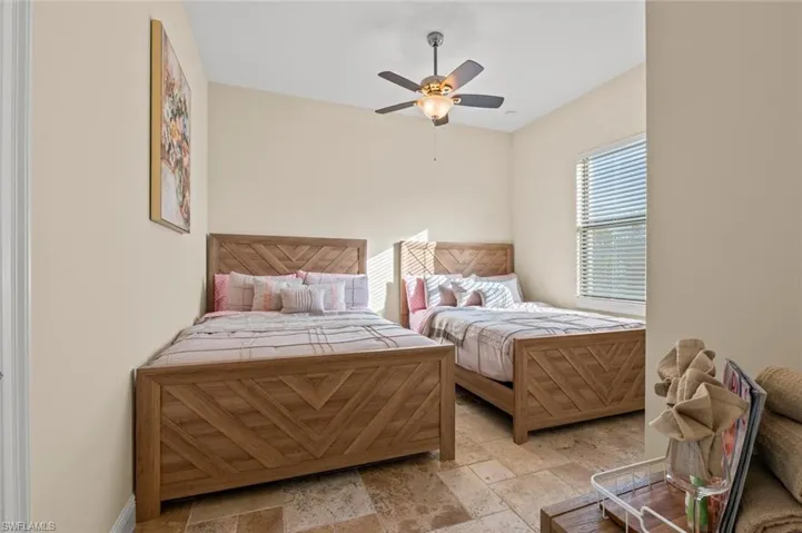 Bedroom featuring stone tile flooring and a ceiling fan