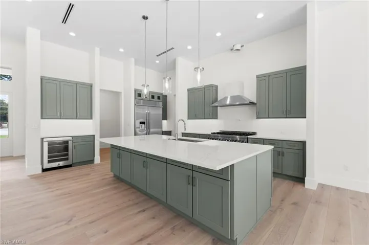 Kitchen with access to garage, butlers kitchen and laundry. Gas range hood is not completed yet as well as pot filler faucet.