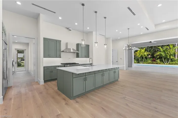 Kitchen with access to garage, butlers kitchen and laundry. Gas range hood is not completed yet as well as pot filler faucet.