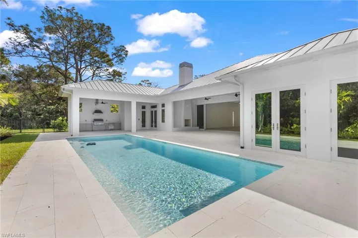 Large swimming pool with natural stone deck. Summer kitchen