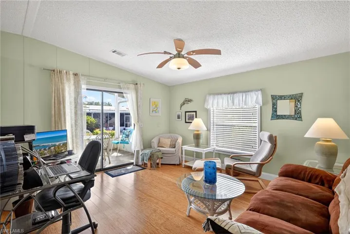Office space featuring a ceiling fan, wood finished floors, and healthy amount of natural light