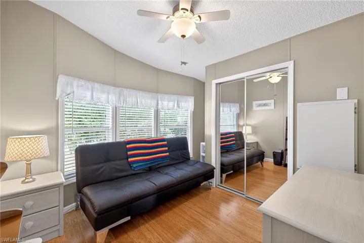 Sitting room with ceiling fan, a textured ceiling, and light wood-style floors