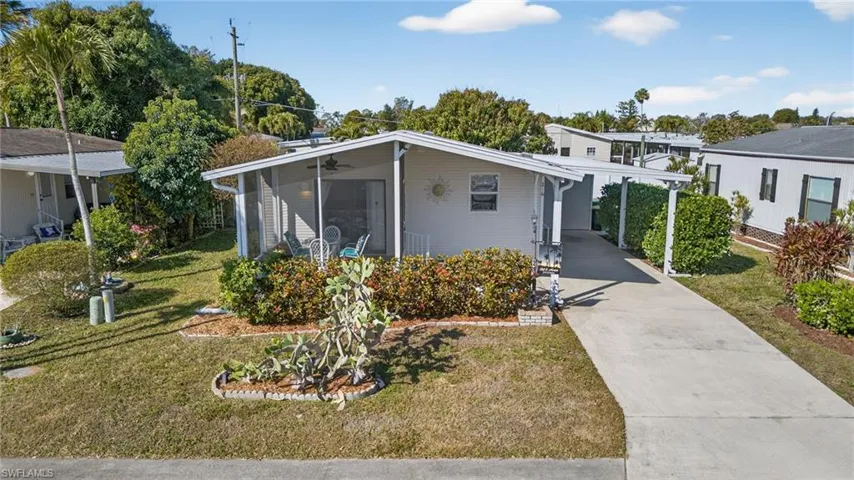 Bungalow with concrete driveway, a front yard, and an attached carport