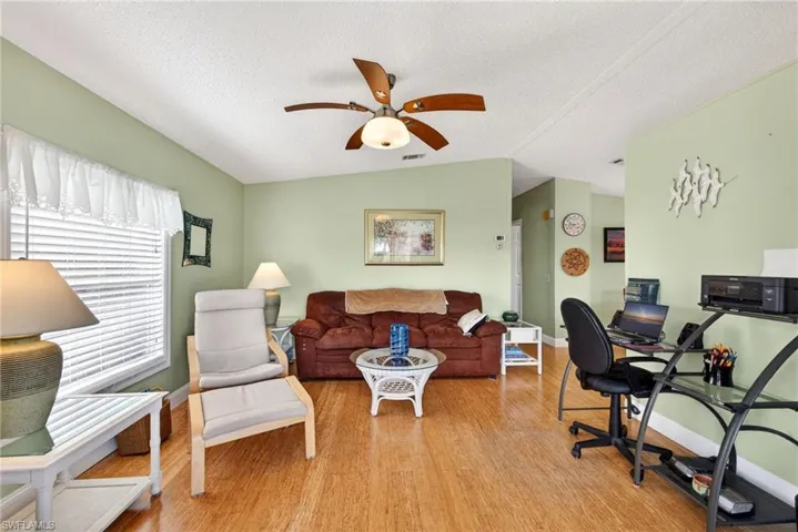 Living room featuring light wood-type flooring and ceiling fan