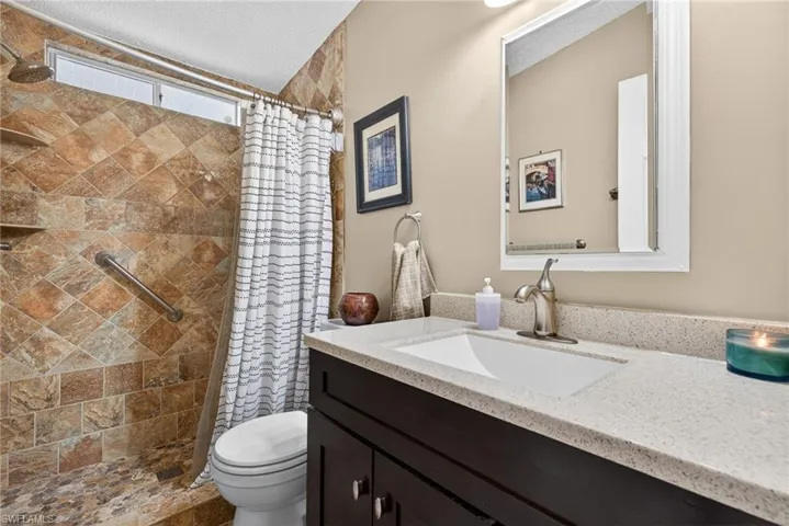 Bathroom featuring a tile shower and vanity